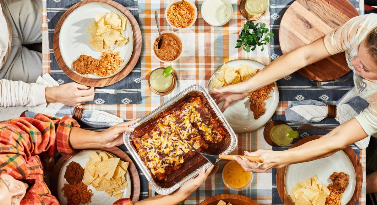 A family gathering with Chuy's food being spread out upon a picnic table.